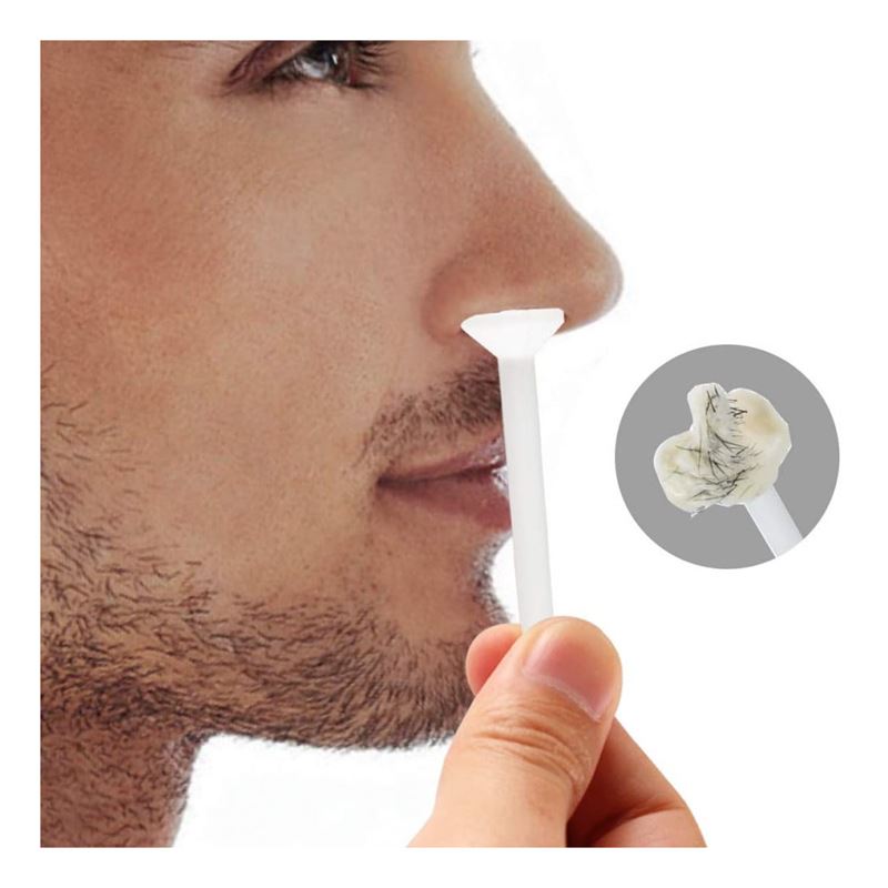A person uses the UNIQ Nose Wax Kit from UNIQ, holding a wax applicator by their nostril to remove nose hair. An inset displays the wax with extracted nose hairs stuck to it.